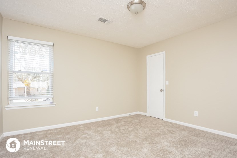 a living room with carpet and a window