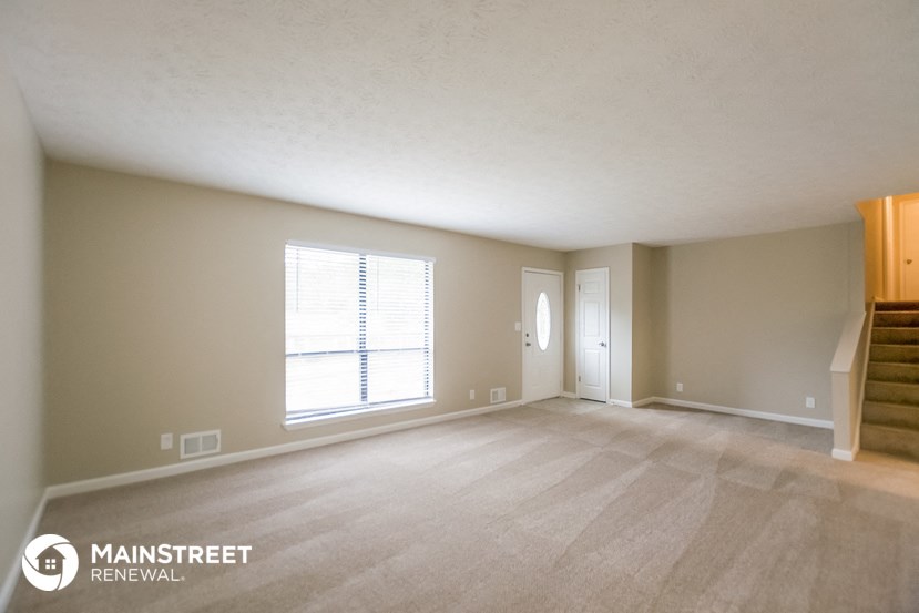the living room of an empty house with a large window