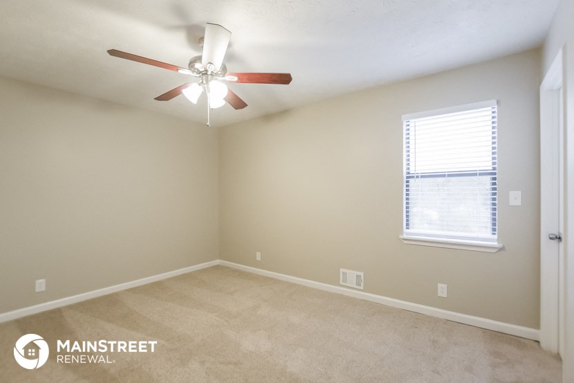 a bedroom with a ceiling fan and a window