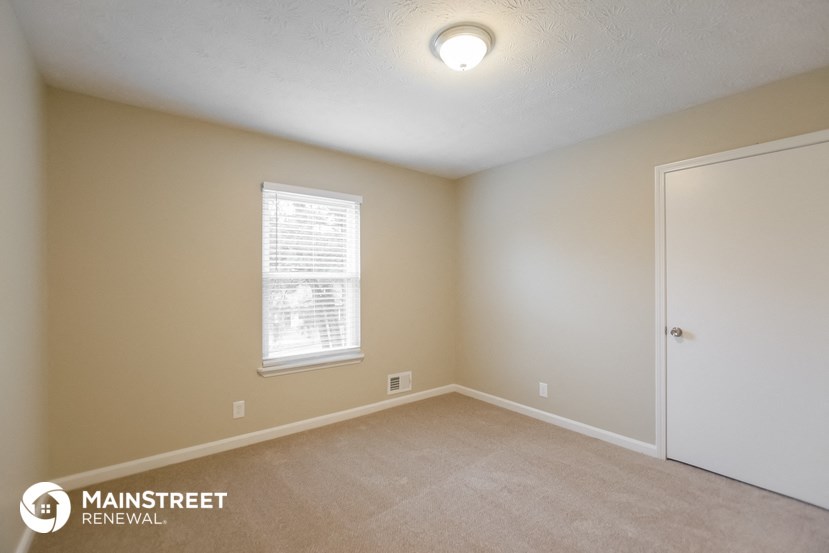 the upstairs bedroom with carpet and a door to the bathroom