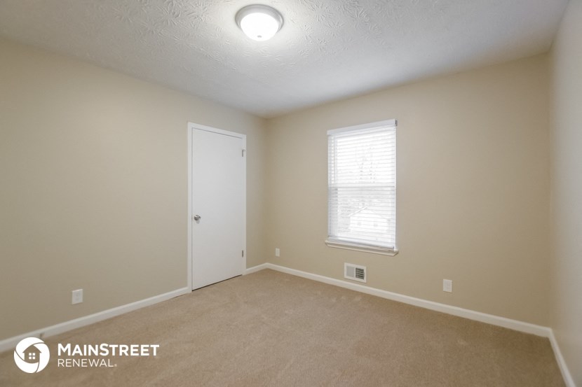 the upstairs bedroom with carpet and a door to the closet