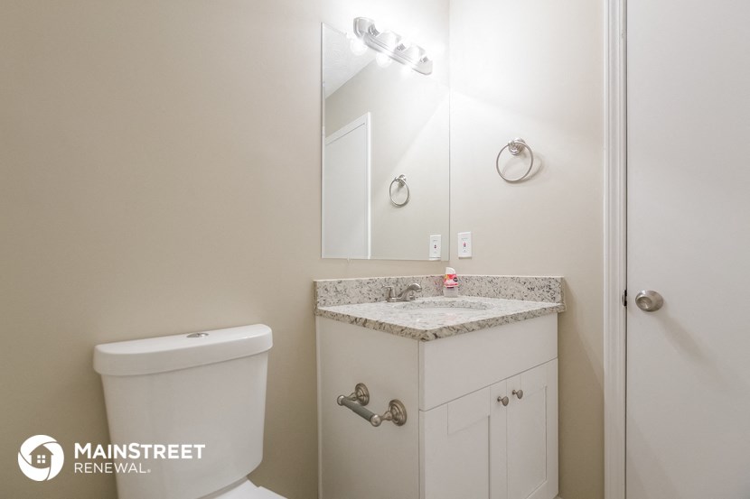 a bathroom with a toilet and a sink and a mirror