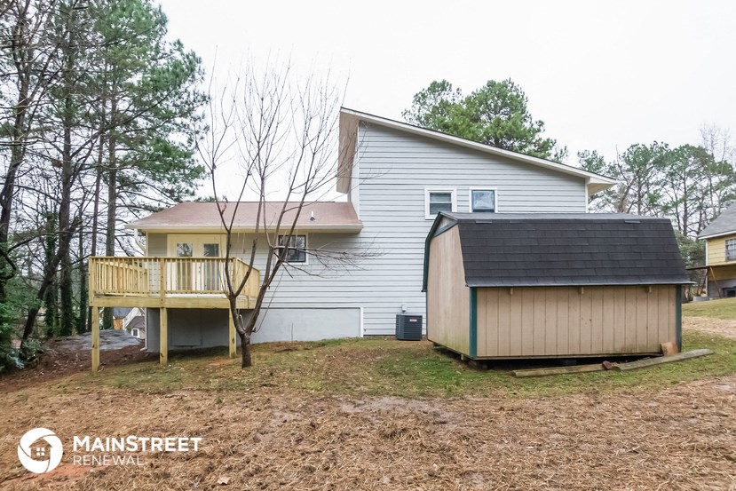 a backyard with a shed and a house with a deck