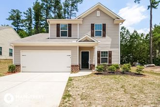 a beige house with a white garage door and a lawn