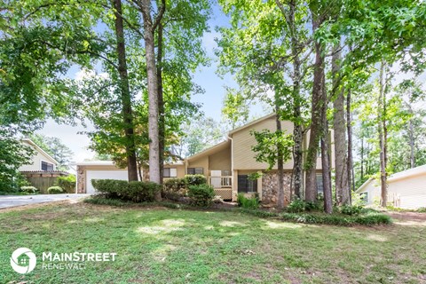 a house with trees and a yard in front of it