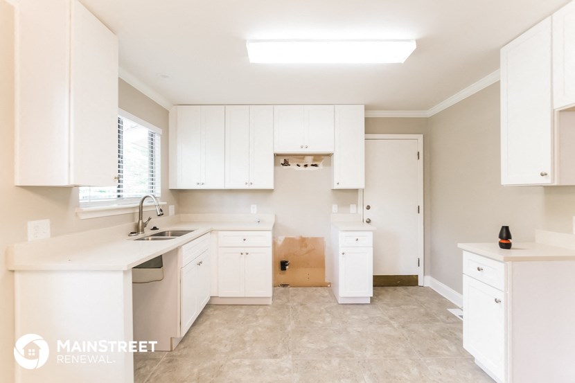 a large white kitchen with white cabinets and a sink