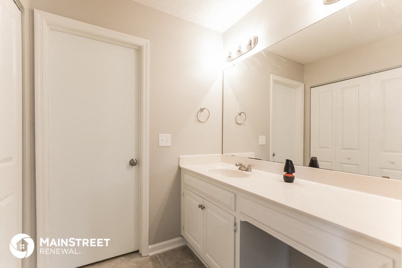 a white bathroom with a large mirror and a sink