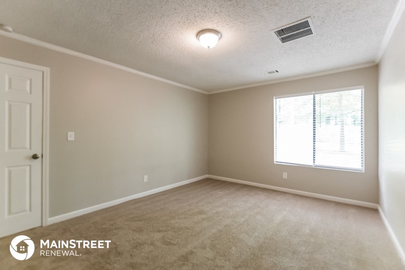 an empty room with a window and a white door
