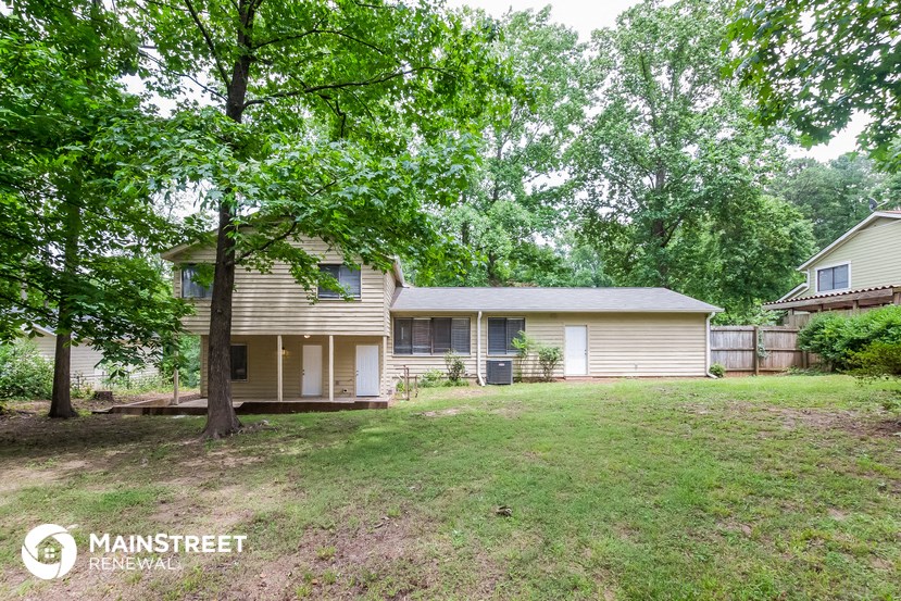 a small house with a yard and some trees