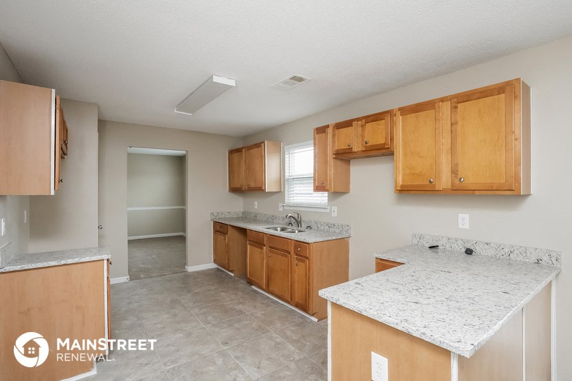 a kitchen with wooden cabinets and marble counter tops and a sink