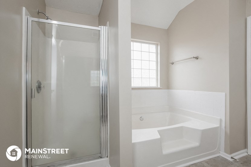 a white bathroom with a shower and a tub