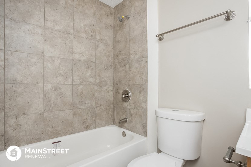 a bathroom with a toilet and a tub and a shower