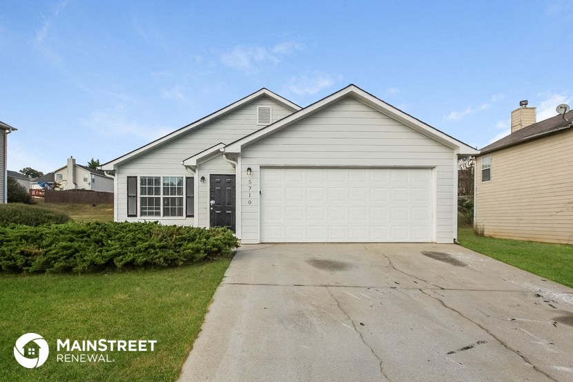 a white house with a driveway and a garage door