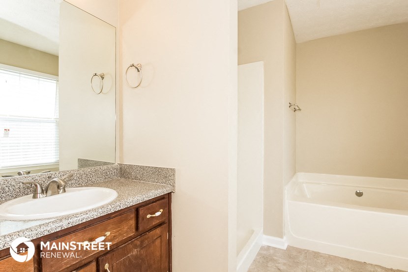 a bathroom with a sink and a tub and a mirror