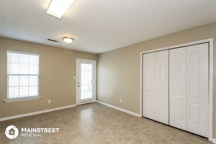 an empty living room with two closets and a door