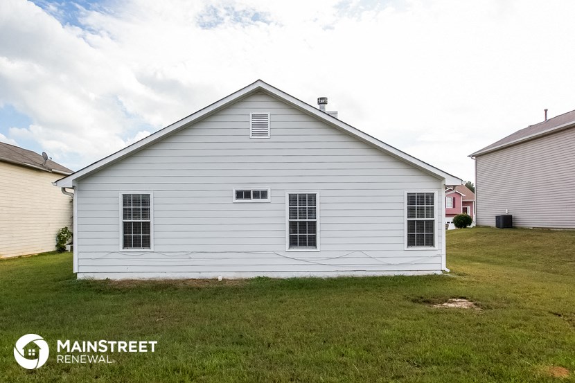 the front of a white house in a grass field