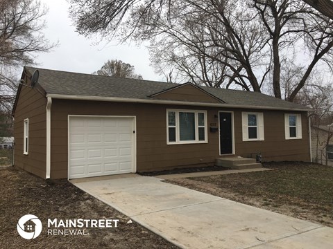 the front view of a brown house with a white garage door