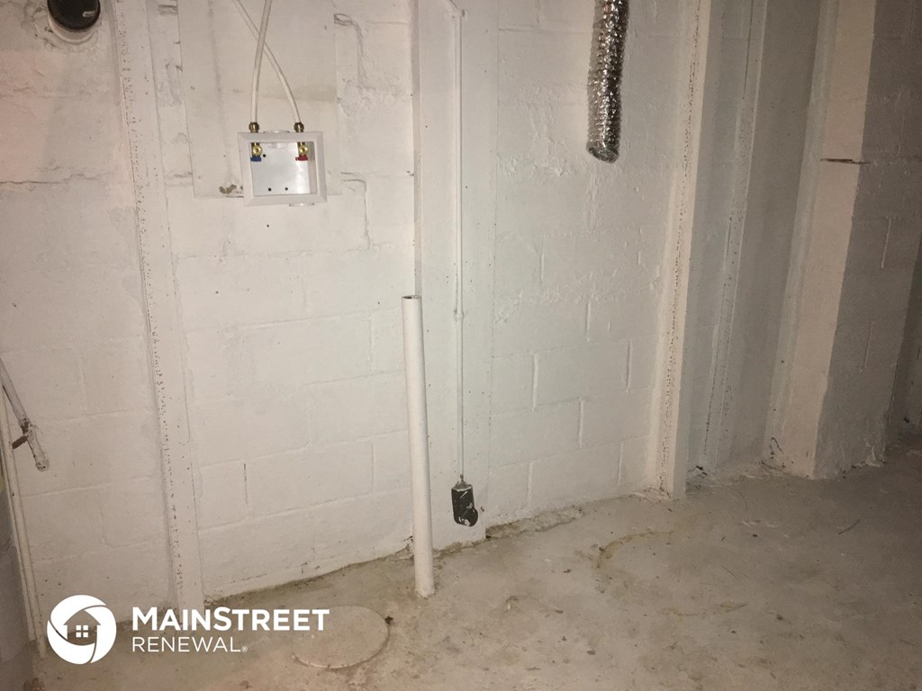 a basement room with a white brick wall and a light on the wall