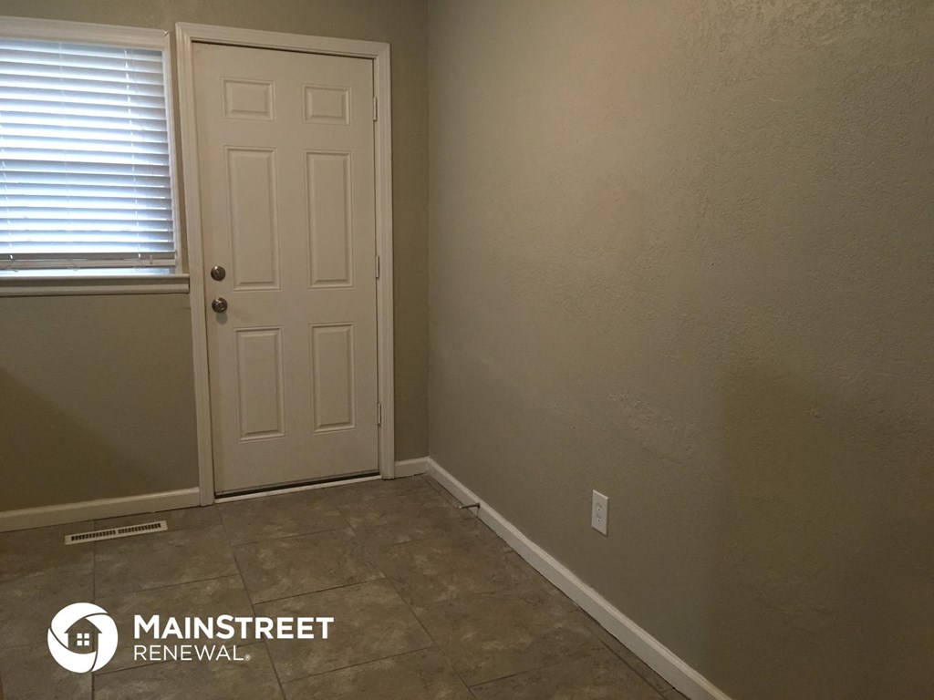 a small room with a white door and a tile floor