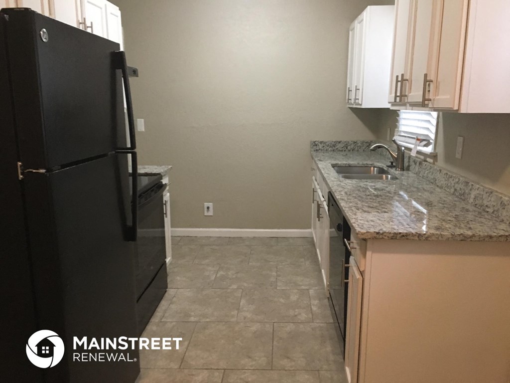 a kitchen with black appliances and granite counter tops