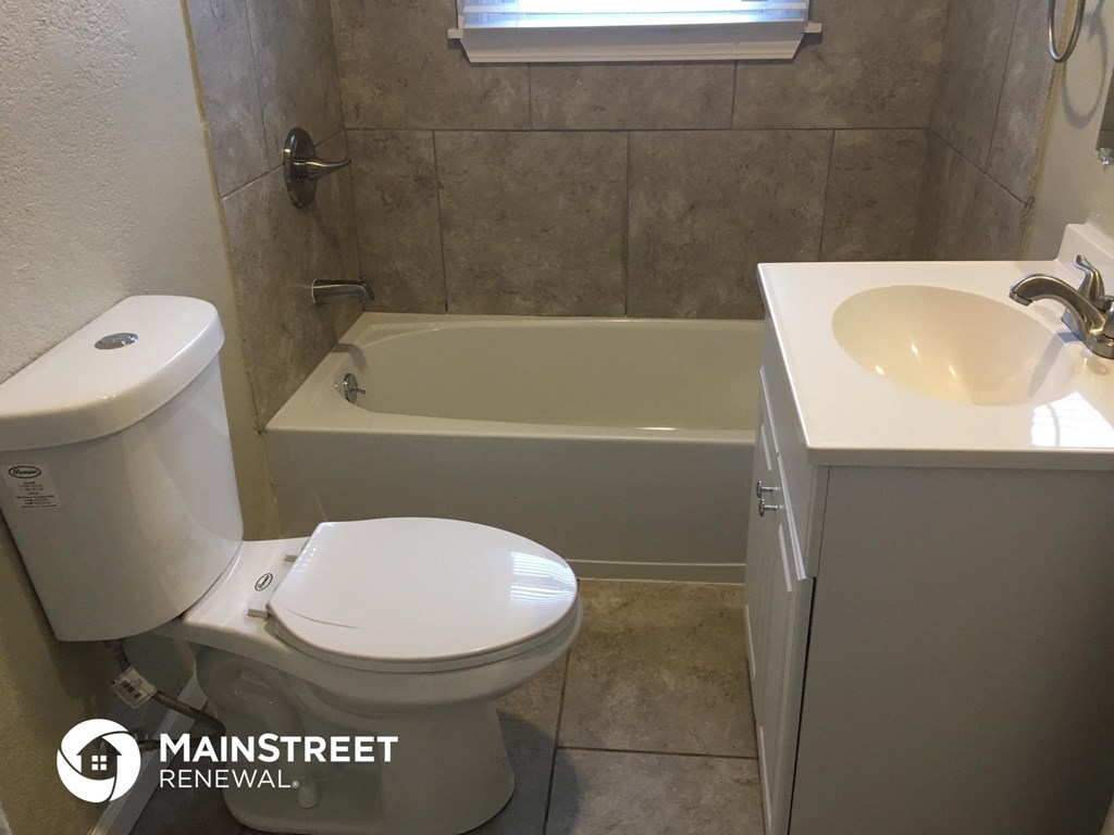 a bathroom with a toilet and a bath tub and a sink