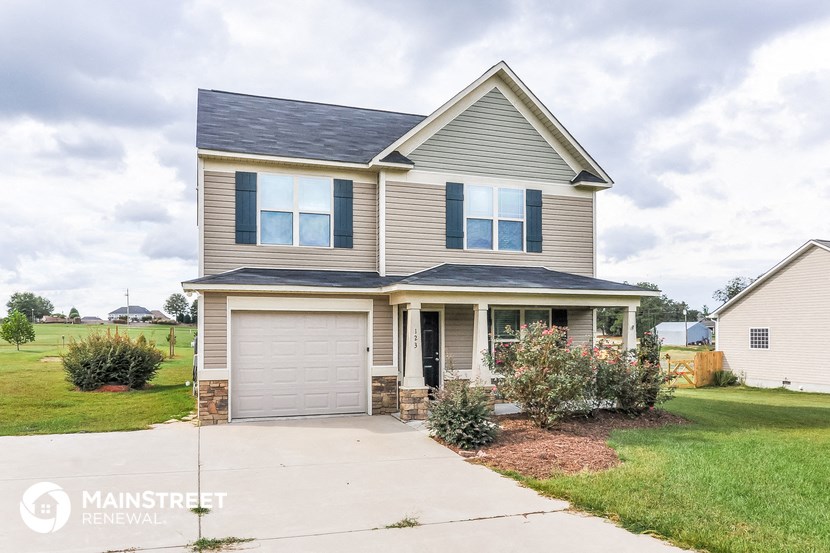 a beige house with a garage and a blue roof