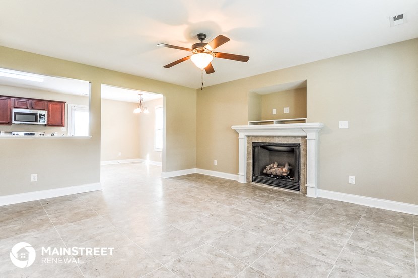 the living room has a fireplace and tile flooring