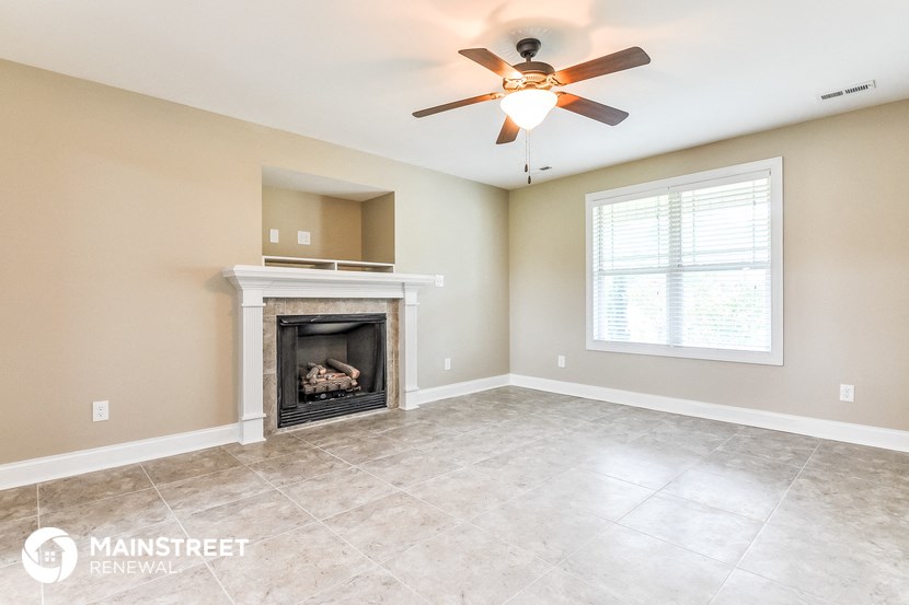 a living room with a fireplace and a ceiling fan