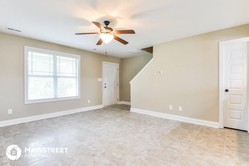 the living room and dining room with a ceiling fan