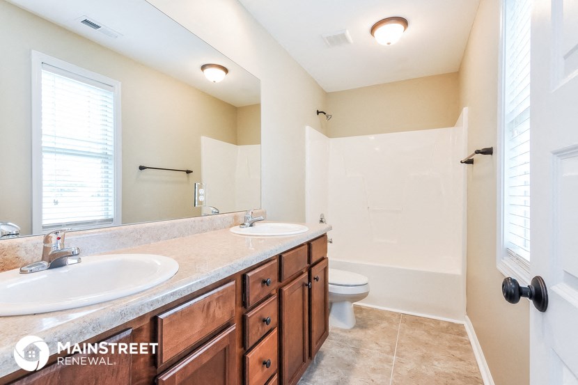 a bathroom with two sinks and a toilet and a shower