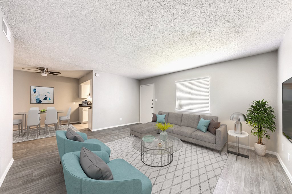 A living room with a grey couch, a glass coffee table, and a television at Alister Apartments, Austin, 78741
