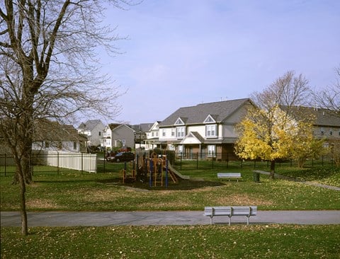 a park with a playground and houses in the background