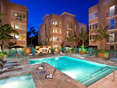 A swimming pool surrounded by lounge chairs and umbrellas at a resort.