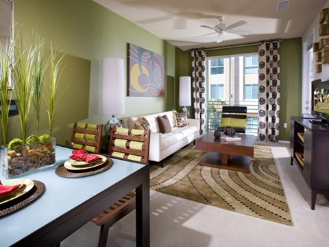 A living room with a white couch, a coffee table, and a dining table with chairs.