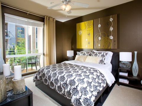 A bedroom with a large bed and a view of a balcony.