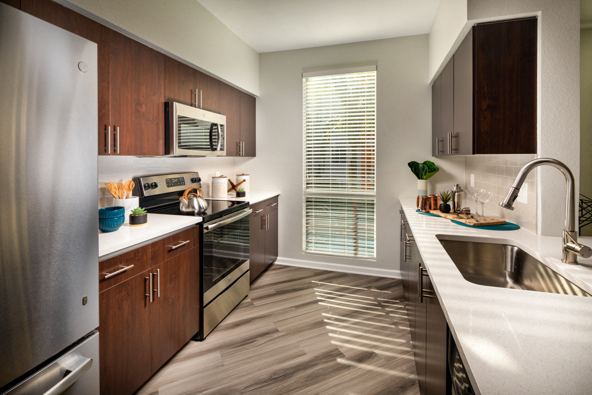 A modern kitchen with wooden cabinets and stainless steel appliances.
