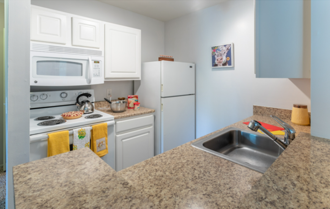 a kitchen with white appliances and granite counter tops