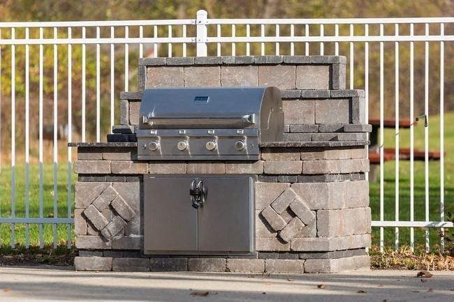 a barbecue grill sitting on top of a stone wall
