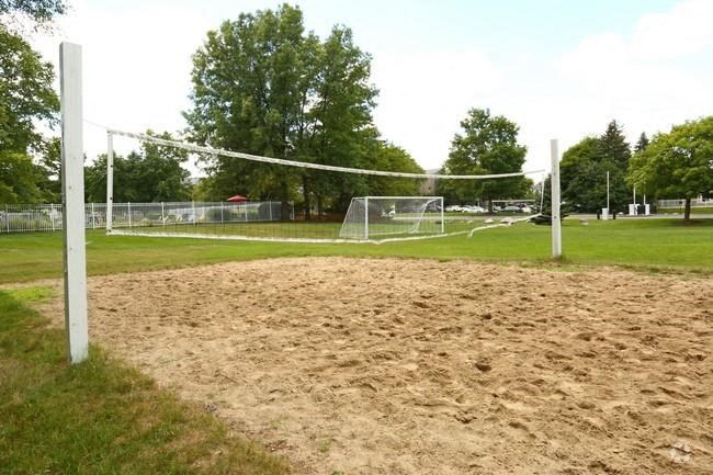 a volleyball court in a park with a net