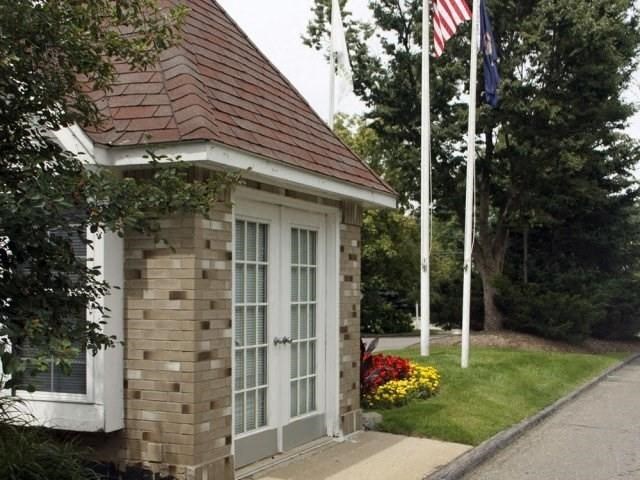 a small brick house with a flag on a pole