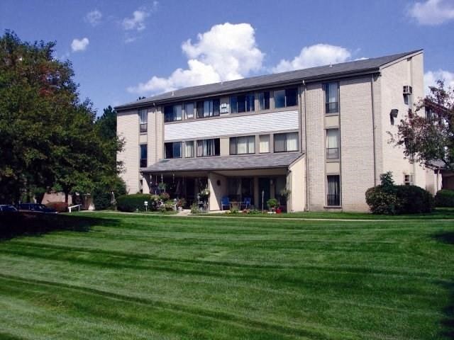 a large building with a green lawn in front of it