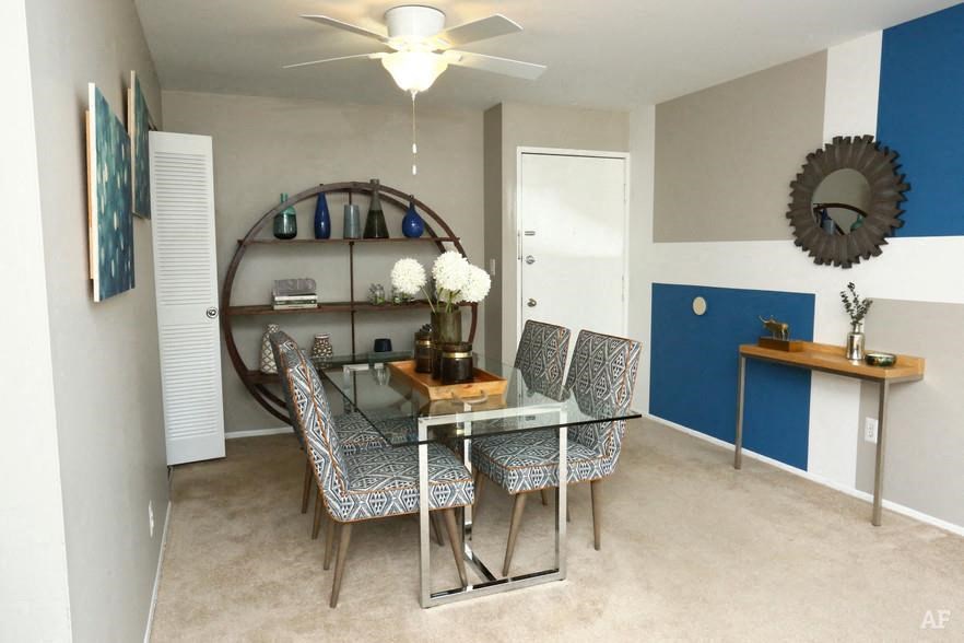 a dining room with a glass table and chairs