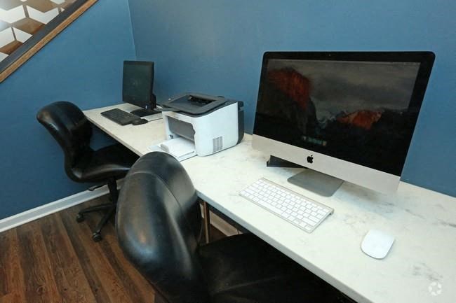 a desk with a computer and a printer on it