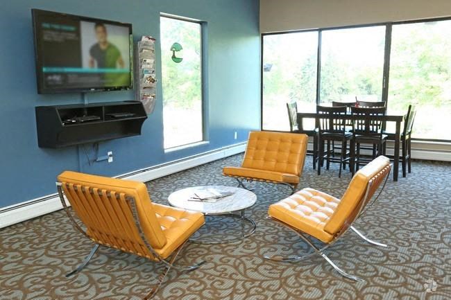 a living room with two yellow chairs and a television