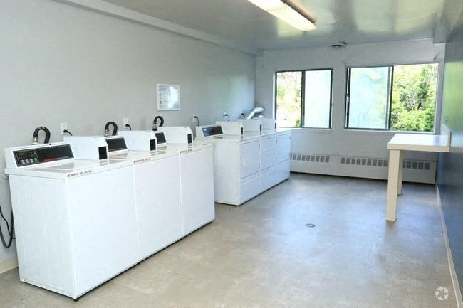 a group of white washing machines in an empty room