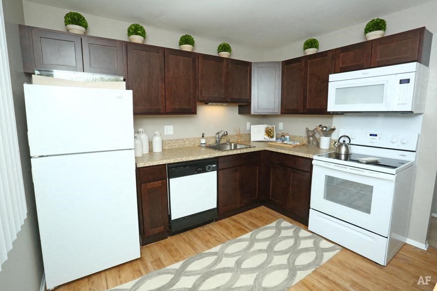 a kitchen with white appliances and brown cabinets
