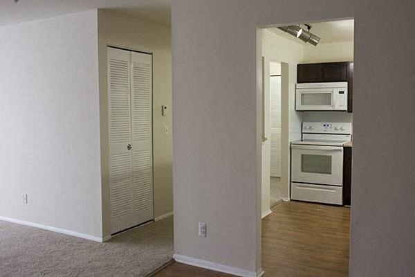 an empty room with a kitchen and a door