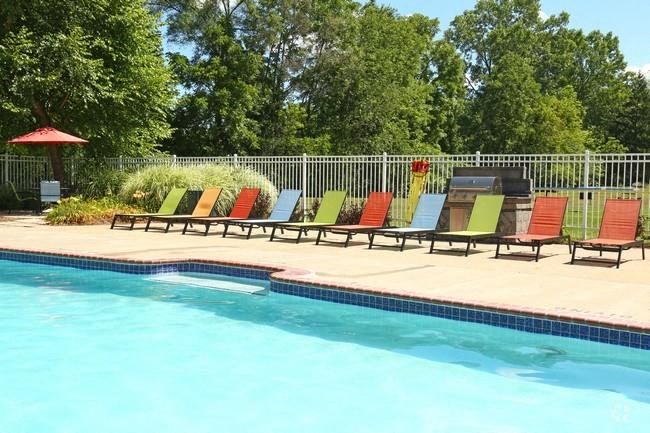 a swimming pool with a row of colorful chairs
