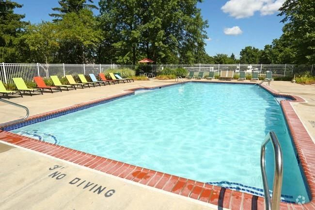 a large swimming pool with chairs around it