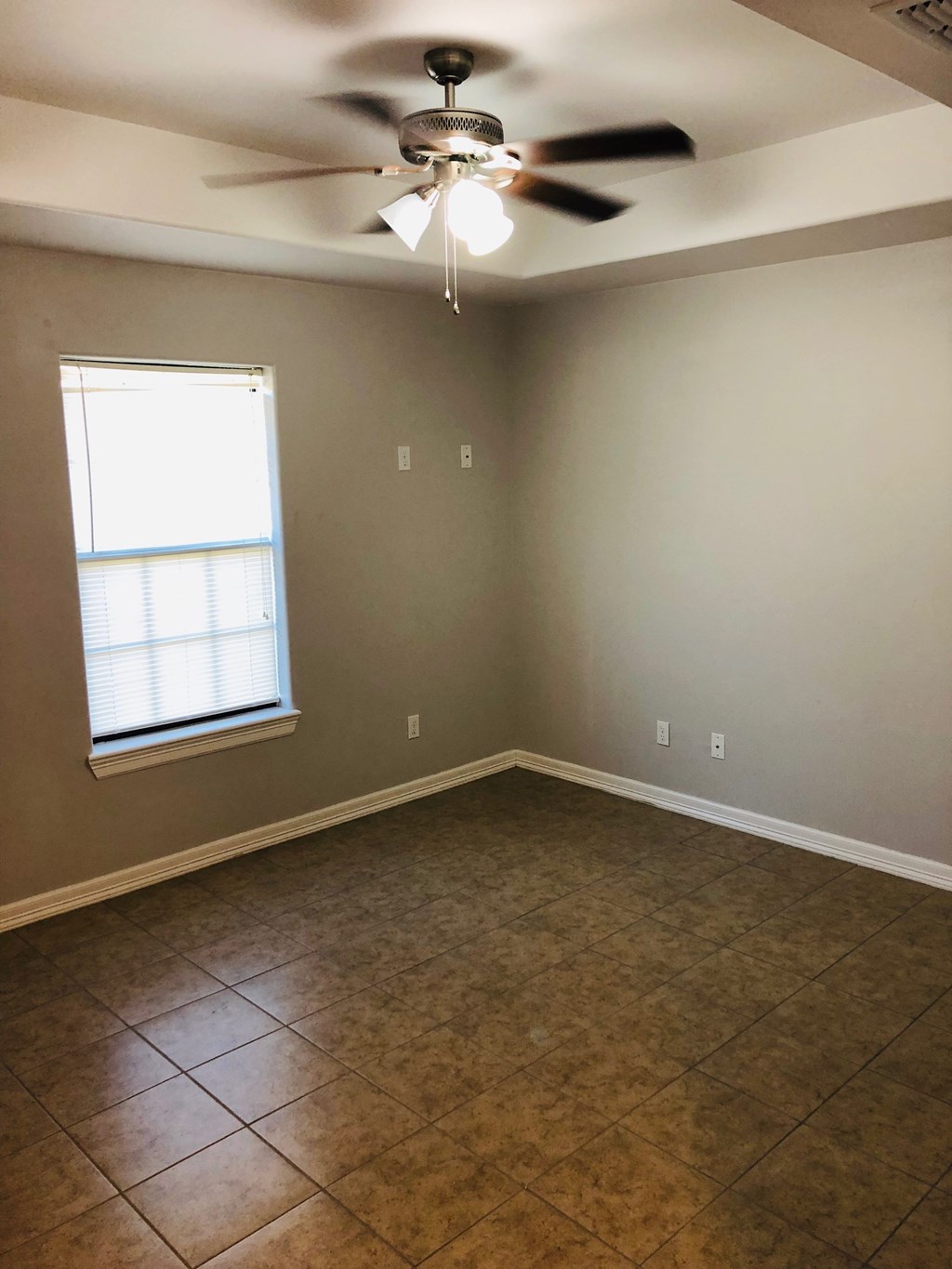 a empty room with a ceiling fan and a window